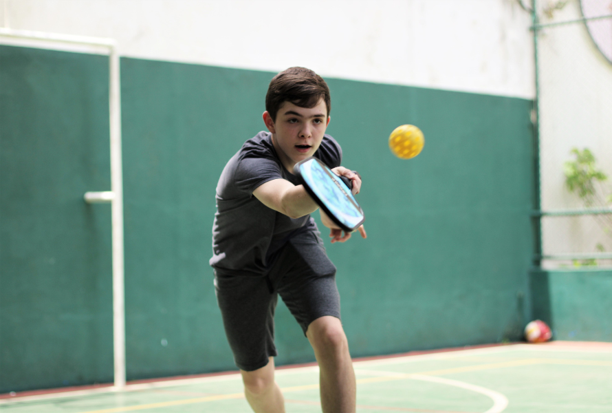 Beginner pickleball player practicing dink shots near the kitchen line