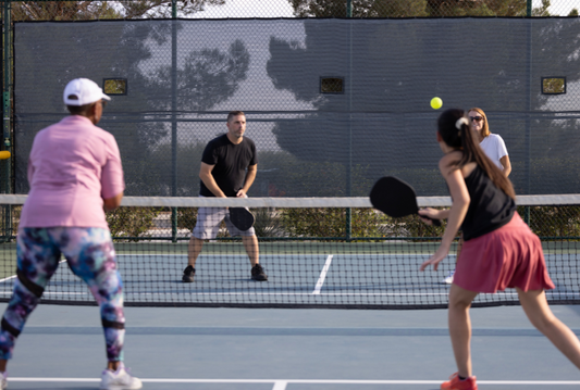 Pickleball players practicing drills and refining their strategy on the court