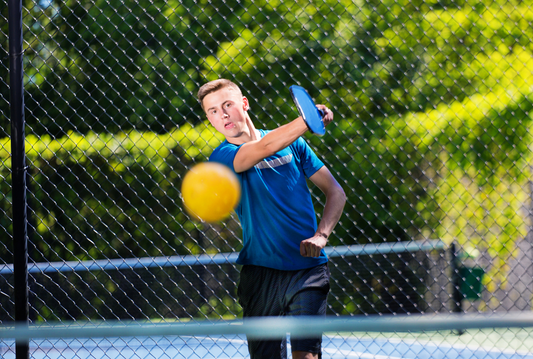Player practicing a dinking drill on a pickleball court