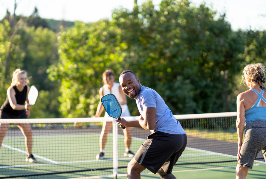 Players enjoying an outdoor pickleball match on a sunny day at a public park