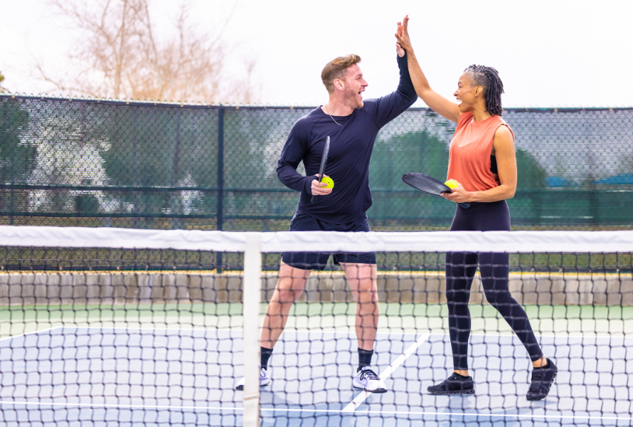 Pickleball players strategizing on the court, discussing doubles positioning and shot tactics